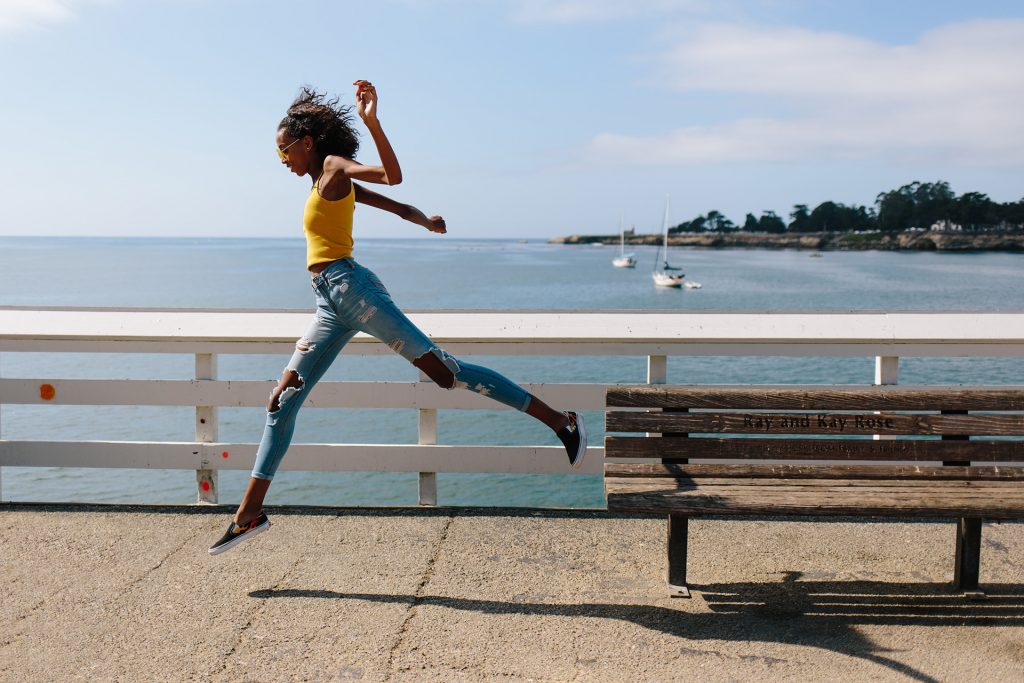 Stars management model jumping off bench during lifestyle photo shoot in Santa Cruz, California