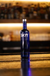 SKYY Vodka bottle in a bar with warm lighting behind photographed for a advertising campaign comissioned by the Compari Group
