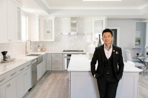 San Jose realtor Anson Ip standing in front of a kitchen island for an environmental portrait