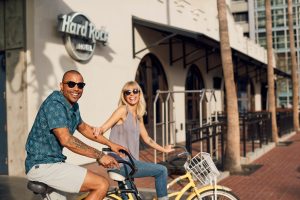 A couple riding bikes they had rented from the Hard Rock Hotel