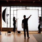 Assistants helping Anthony Baca on set of a photoshoot